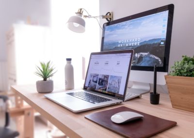 MacBook Pro on table beside white iMac and Magic Mouse
